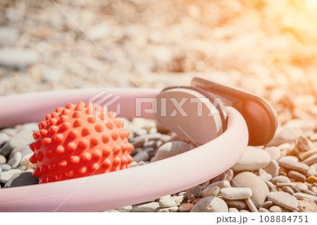 Pilates magic ring and rubber band on yoga mat near sea. Female fitness yoga concept. Healthy lifestyle harmony and meditation. Pilates magic ring and rubber band on yoga mat near sea. Female fitness yoga concept. Healthy lifestyle harmony and meditation. 108884751