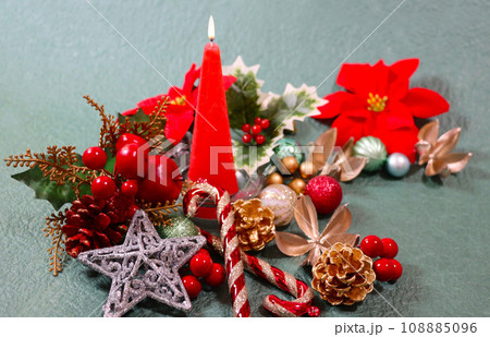 炎が揺らぐ赤いキャンドルとカラフルなクリスマスオーナメント　クリスマス背景 108885096