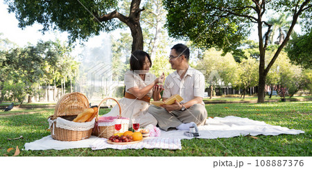 Cheerful elderly couple asian wear casual clothes sitting in the park having a party together 108887376