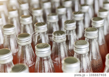 Juice in glass bottles in factory to fill with drink. 108887408