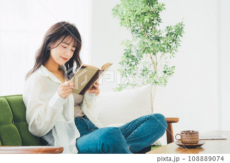 ソファに座って本を読む女性 108889074