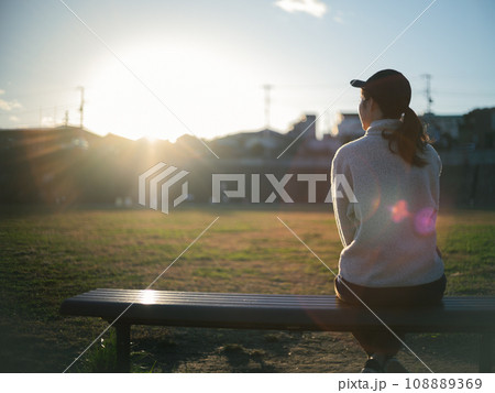 夕方の公園で座っている女性 夕方の公園で座っている女性 108889369