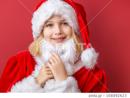 クリスマクリスのイメージの人物写真、サンタクロースの帽子をかぶった若い笑顔の白人の女性　AI生成画像 108892623