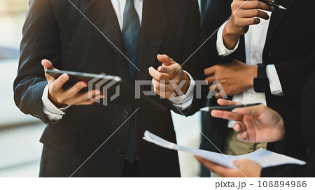 Group of businesspeople using digital tablet analyzing financial data and planning work at meeting Group of businesspeople using digital tablet analyzing financial data and planning work at meeting 108894986