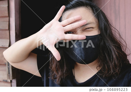 Asian Thai woman wearing a black cloth mask for prevent the Covid-19 or Corona virus and Epidemic disease at Thailand and around the world. Air pollution pm2.5. Health and illness concept Asian Thai woman wearing a black cloth mask for prevent the Covid-19 or Corona virus and Epidemic disease at Thailand and around the world. Air pollution pm2.5. Health and illness concept 108895223