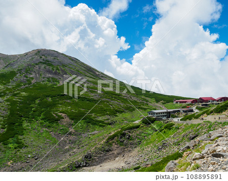 剣が峰からの入道雲と山小屋 108895891