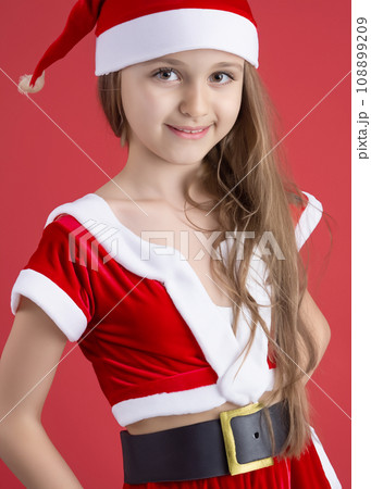 クリスマスのイメージの人物写真、サンタクロースの衣装を着た笑顔の白人の少女　コスプレ　AI生成画像 108899209