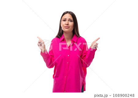 smart young brunette woman in a bright pink shirt points her finger at the space for advertising on smart young brunette woman in a bright pink shirt points her finger at the space for advertising on 108900248