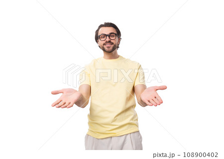 a benevolent caucasian guy with a beard in glasses dressed in a light T-shirt holds out his hands 108900402