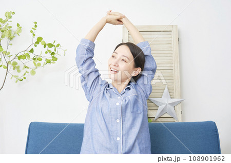 自宅でパジャマを着て伸びをするミドルエイジの女性 自宅でパジャマを着て伸びをするミドルエイジの女性 108901962