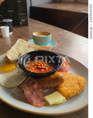 Full English breakfast with beans and sausage served on wooden table Full English breakfast with beans and sausage served on wooden table 108904593