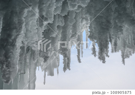 ice caves of Lake Baikal. Frozen icicles and splashes. Frozen lake Baikal in winter in Russia 108905875