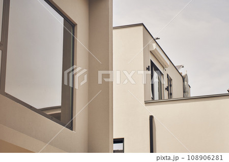 Exterior of the hotel building with mirrored glass windows. Part of the building in warm colors with space for copying. High quality photo 108906281