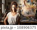 Portrait of beautiful passionate artist in her mid-20s, wearing a worn-out denim  108906375