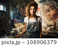 Portrait of young passionate artist in her mid-20s, wearing a worn-out denim  108906379