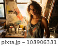 Portrait of young passionate female artist, wearing a worn-out denim apron 108906381