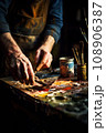 A close-up shot of the artist's hands, mixing paint on a palette 108906387