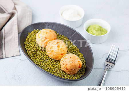 cooked meatballs on peas in an oblong bowl 108906412