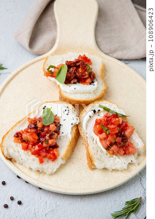 bruschetta with tomatoes and labneh cheese on a light background bruschetta with tomatoes and labneh cheese on a light background 108906423