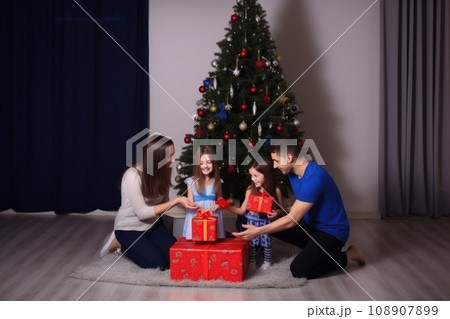 happy family with Merry Christmas magic gift near tree at evening at home 108907899