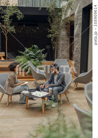 Smiling female manager is making notes during meeting with colleague in coworking space Smiling female manager is making notes during meeting with colleague in coworking space 108909614