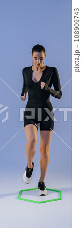 Fitness woman doing cardio training using special professional equipment on studio background 108909743