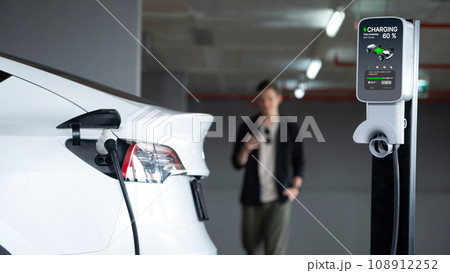 Young man travel with EV electric car to shopping center parking lot innards 108912252