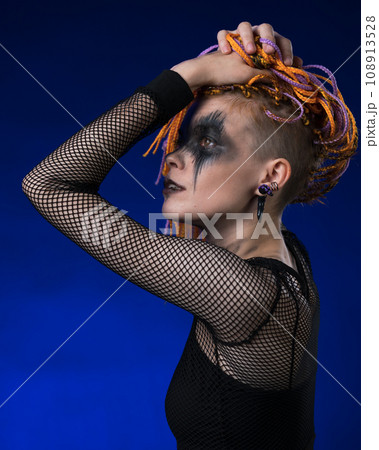 Cinematic portrait of beauty woman with colored braids hairdo, spooky stage make-up painted on face Cinematic portrait of beauty woman with colored braids hairdo, spooky stage make-up painted on face 108913528