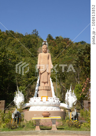 An outdoor standing Buddha image made of sandstone, beautiful appearance, enshrined on the stairs leading up to Wat Phutthawat Phu Sing temple. Located at Kalasin Province in Thailand. An outdoor standing Buddha image made of sandstone, beautiful appearance, enshrined on the stairs leading up to Wat Phutthawat Phu Sing temple. Located at Kalasin Province in Thailand. 108913852