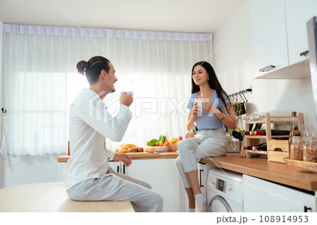 Romantic young couple drinking coffee together in the kitchen Romantic young couple drinking coffee together in the kitchen 108914953