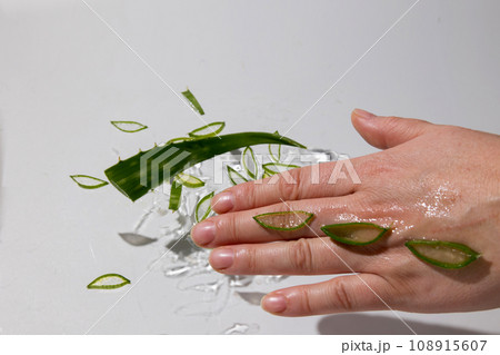 Aloe drops fall and moisturize the skin of female hands 108915607