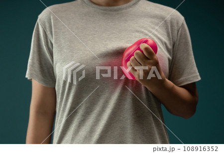 Painful, Heart Attack Concept. Young Adult Woman Squeezed a Red Balloon against her Chest. Heart Disease or feeling very Heartbreak and Sorrow 108916352
