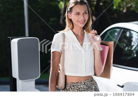 Young woman travel with EV electric car in green sustainable city innards Young woman travel with EV electric car in green sustainable city innards 108917804