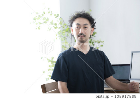 スクラブを着た男性医者 カメラ目線の真剣な表情 スクラブを着た男性医者 カメラ目線の真剣な表情 108917889