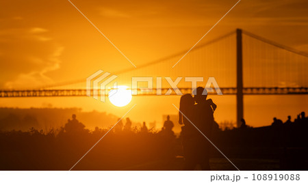 Sunset Silhouette: Two People have hag and kiss in Front of a big Bridge Sunset Silhouette: Two People have hag and kiss in Front of a big Bridge 108919088