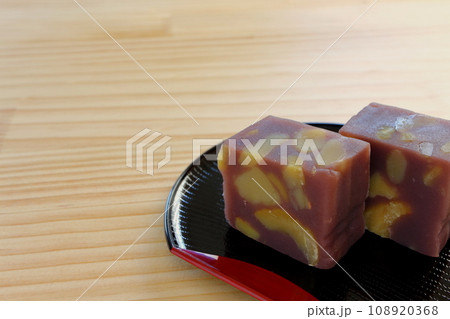 木のテーブルの上に置かれた半月盆に盛りつけた栗蒸し羊羹 木のテーブルの上に置かれた半月盆に盛りつけた栗蒸し羊羹 108920368