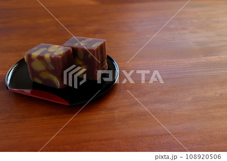 木のテーブルの上に置かれた半月盆に盛りつけた栗蒸し羊羹 木のテーブルの上に置かれた半月盆に盛りつけた栗蒸し羊羹 108920506