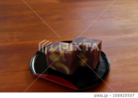 木のテーブルの上に置かれた半月盆に盛りつけた栗蒸し羊羹 108920507