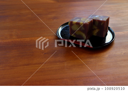 木のテーブルの上に置かれた半月盆に盛りつけた栗蒸し羊羹 108920510