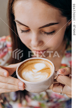 Young beautiful stylish woman drinking coffee while sitting in restaurant and eating tasty dish Young beautiful stylish woman drinking coffee while sitting in restaurant and eating tasty dish 108922498
