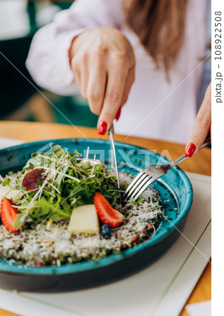 Close up of woman eating beef carpaccio with pesto sauce and parmigiano cheese. Restaurant menu Close up of woman eating beef carpaccio with pesto sauce and parmigiano cheese. Restaurant menu 108922508