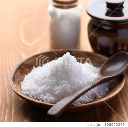 海水を天日干しで作った粗塩の海塩と塩の入った壺と瓶 108923205