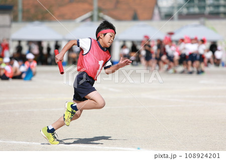 運動会のリレー競技で走る小学生 108924201