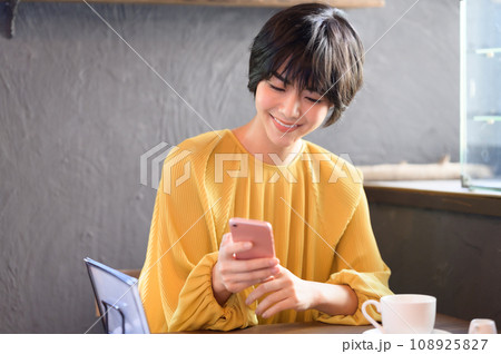 カフェでスマホを手に取る女性　撮影協力「洋菓子店　sentiment」 108925827