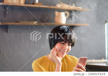 カフェでスマホを手に取る女性　撮影協力「洋菓子店　sentiment」 108925839
