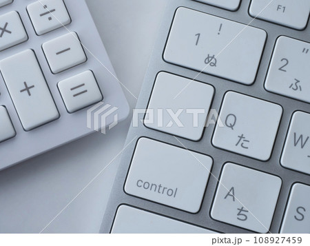 テーブルに置かれたキーボードと電卓 108927459