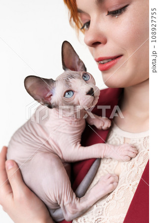 Hipster young redhead woman hugging cat. Selective focus on domestic kitten, shallow depth of field Hipster young redhead woman hugging cat. Selective focus on domestic kitten, shallow depth of field 108927755