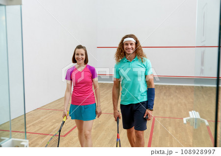 Satisfied man and woman athlete after successful squash game 108928997
