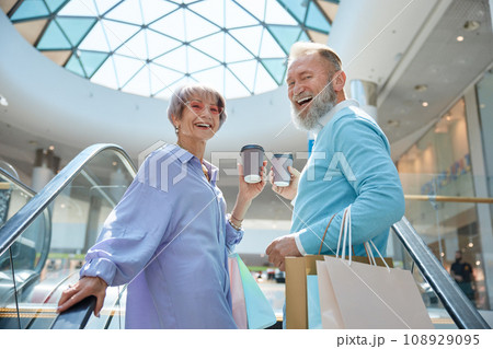 Adult senior couple with purchases having fun time at shopping mall 108929095