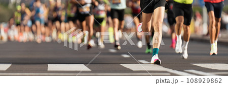 Marathon runners running on city road, large group of runners, close-up legs runners running sport marathon, male jogging race in asphalt road, athletics competition 108929862